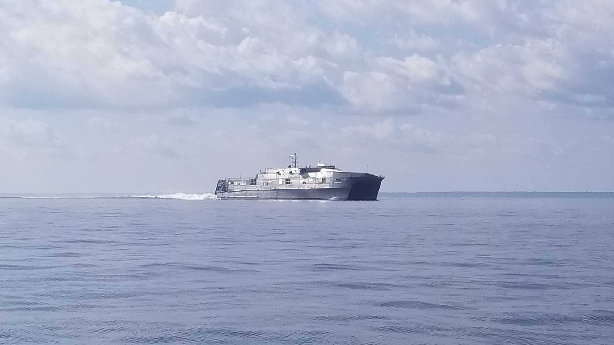 A naval catamaran makes its way north under the Chesapeake Bay Bridge.